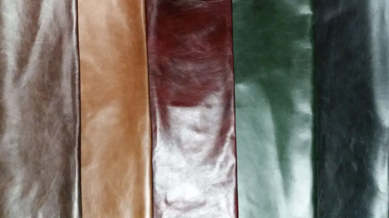 Pięć pasów skóry anilinowej w odcieniach brązu, bordo, zieleni i grafitu. Naturalne zagniecenia i połysk podkreślają jej jakość.
