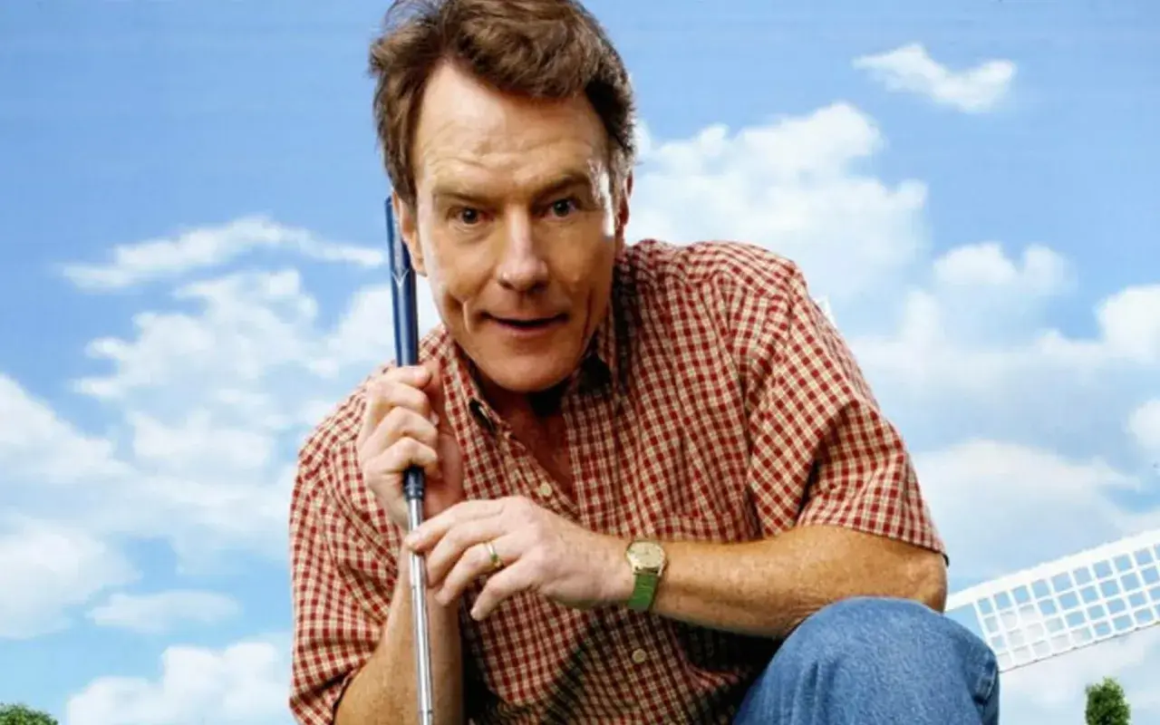 Bryan Cranston w kratę, z kijem golfowym, przypomina postać z jego filmów i seriali.