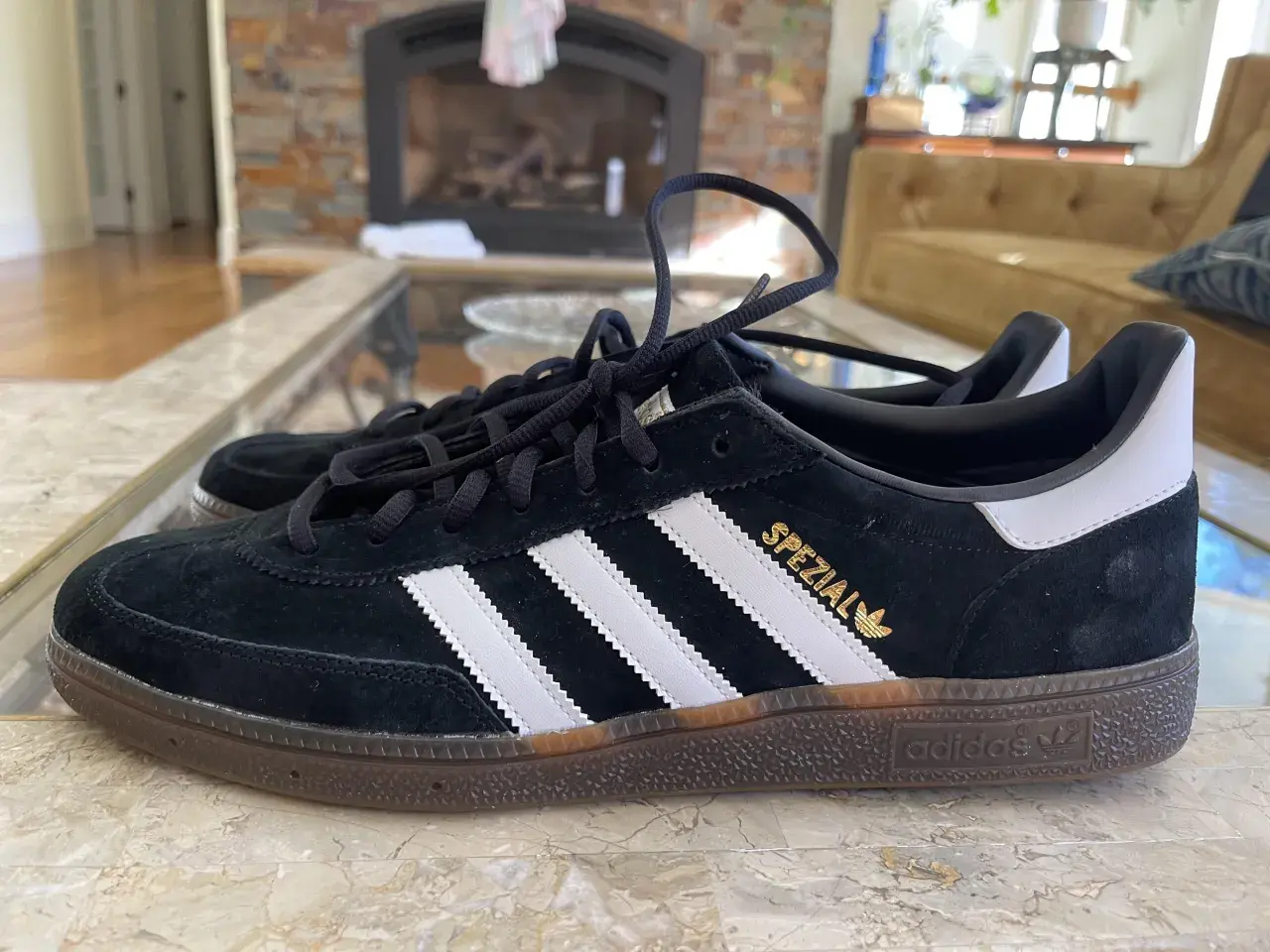 Czarne buty Adidas Spezial z białymi paskami i złotym napisem. Zwróć uwagę na detale, jak rozpoznać oryginalne buty Adidas.