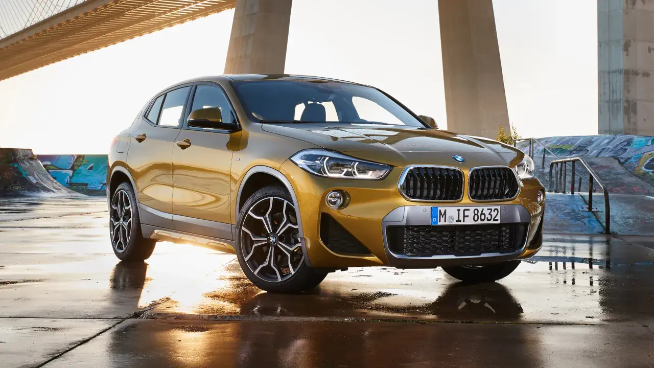 Złoty BMW X2 na tle mostu i skateparku. Nowoczesny leasing jak abonament, bez zobowiązań.