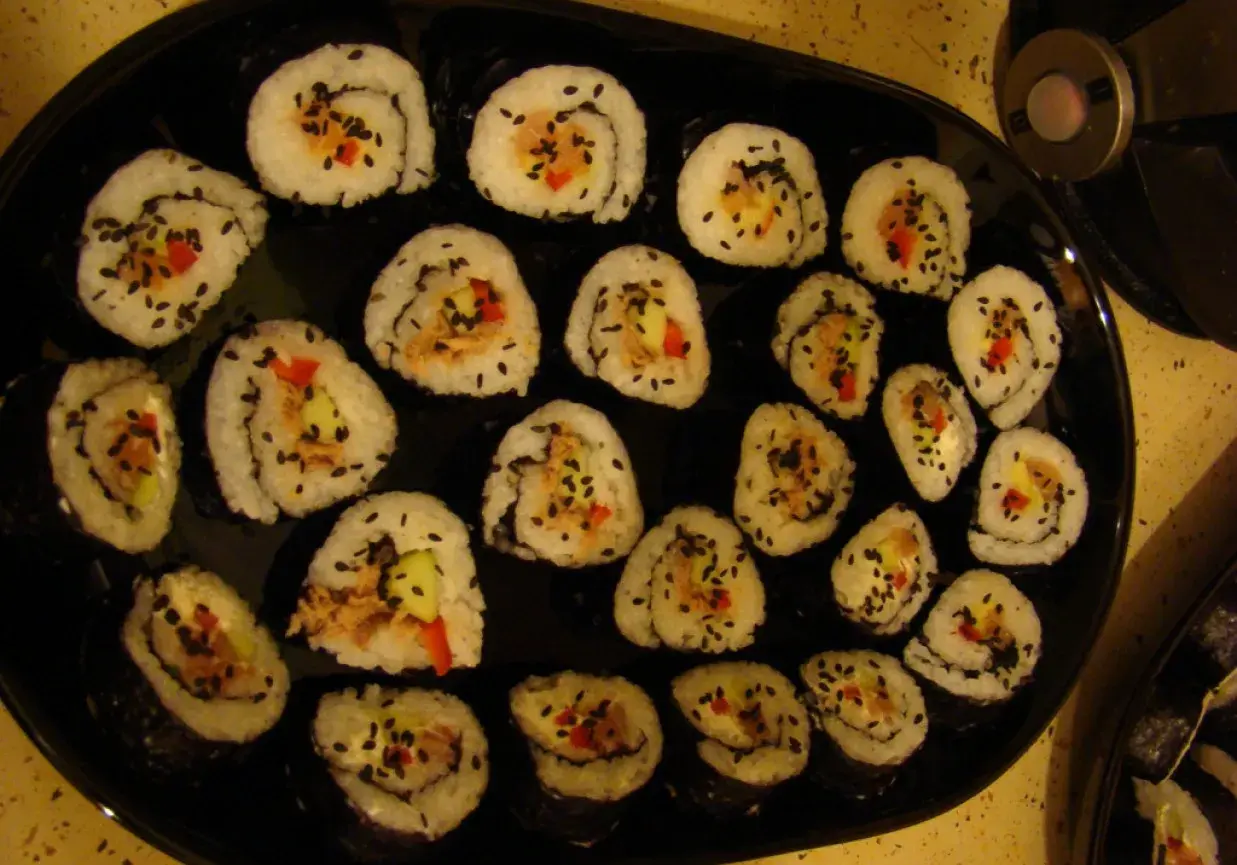 Roladki sushi z tuńczykiem, ogórkiem i papryką, posypane czarnym sezamem. Idealne, gdy zastanawiasz się, jak przygotować tuńczyka do sushi.