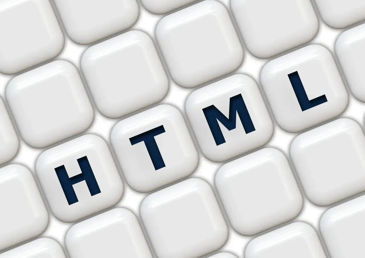 Klawisze z literami H, T, M, L układają się w słowo HTML, symbolizując podstawy programowania.