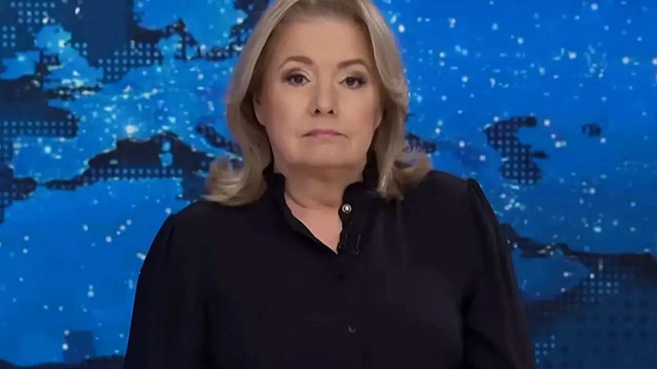 Kobieta w czarnej bluzce na tle mapy świata. Jej poważna mina sugeruje, że omawia ważne wiadomości, które wpływają na oglądalność.
