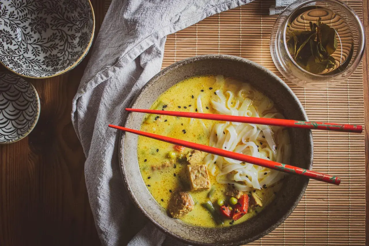Aksamitna zupa laksa z makaronem ryżowym, tofu i warzywami. Idealny przepis na rozgrzewający posiłek.