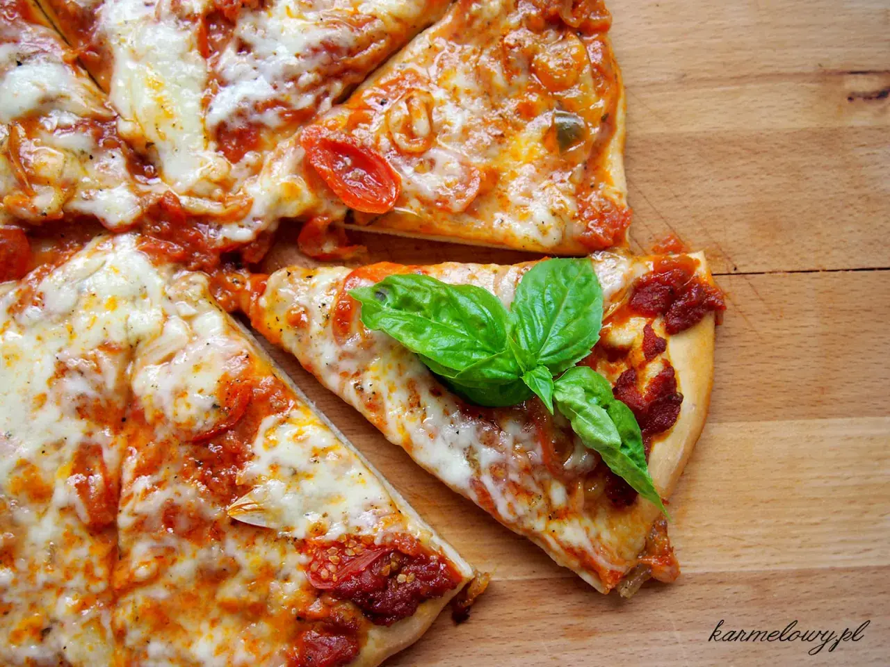 Szybki przepis na ciasto do pizzy: pyszna, domowa pizza z pomidorami i mozzarellą, ozdobiona świeżą bazylią.