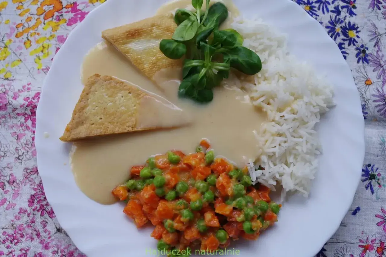 Trójkątne kawałki tofu w kremowym sosie madras, podane z ryżem i warzywami.