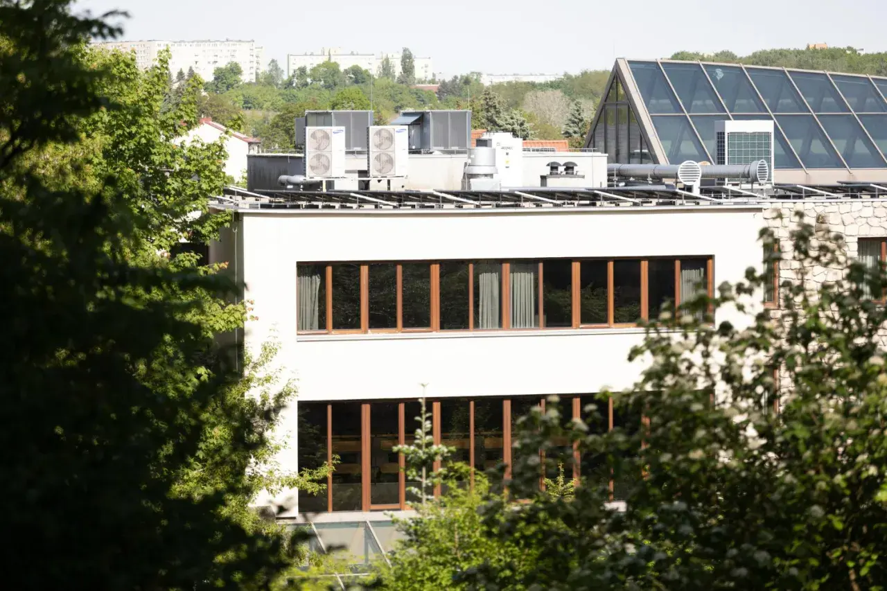 Nowe budynki od września 2026 będą musiały posiadać instalację fotowoltaiczną. Na dachu budynku widać panele i klimatyzatory.