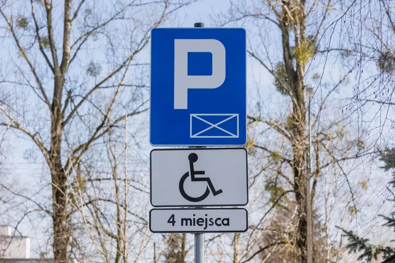 Znak informuje o parkingu dla osób z niepełnosprawnościami. Orzeczenie o niepełnosprawności można uzyskać na wiele chorób, np. schorzenia narządu ruchu.