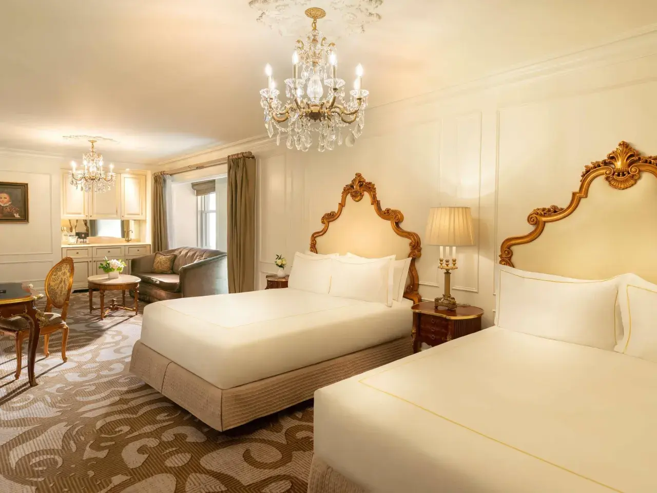 Luksusowy pokój z dwoma łóżkami w hotelu Plaza w Nowym Jorku, z kryształowym żyrandolem i złotymi zdobieniami. Zastanawiasz się, ile kosztuje noc w hotelu Plaza w Nowym Jorku?