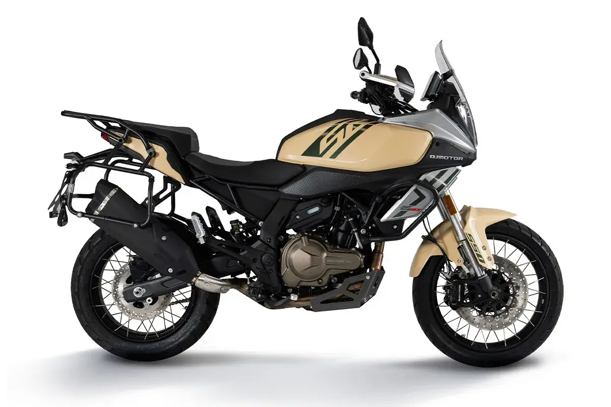 Beżowy motocykl turystyczny z bagażnikami, gotowy na dalekie wyprawy.