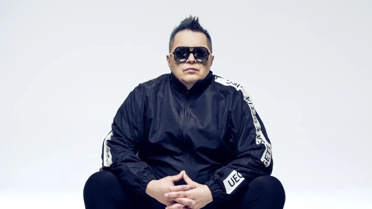 Marek "Mrozu" Mróz w okularach i czarnej kurtce z napisem "GETTA", jakby szykował się na koncert zespołu Munka Staszczyka.