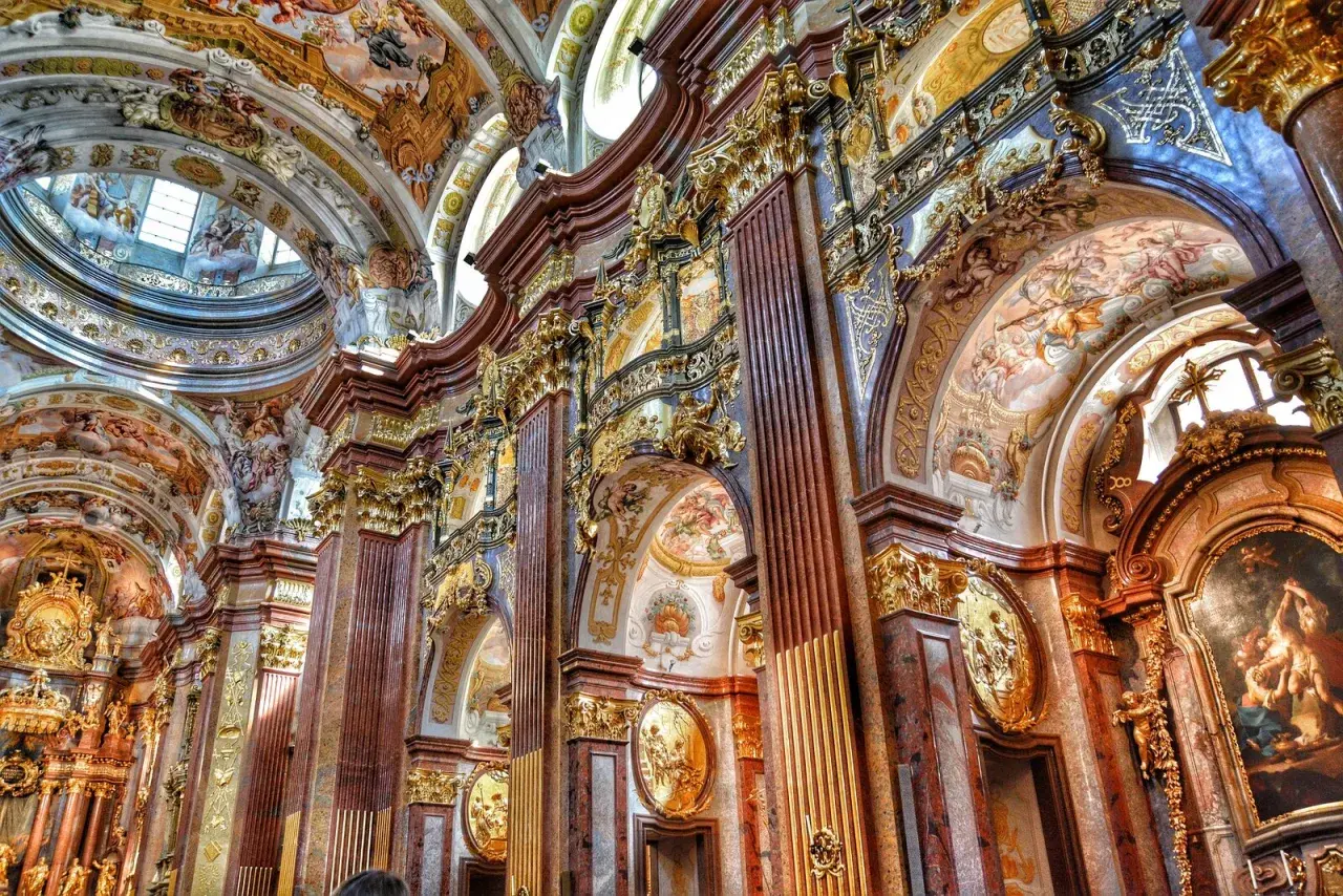 Bogata architektura baroku zachwyca złotymi zdobieniami, marmurowymi kolumnami i freskami na sklepieniach.
