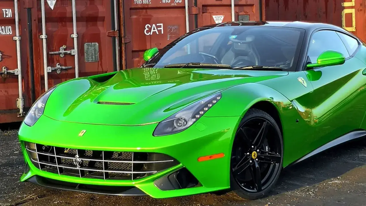 Jaskrawozielone Ferrari F12 Berlinetta z czarnymi felgami, zaparkowane przed czerwonym kontenerem.