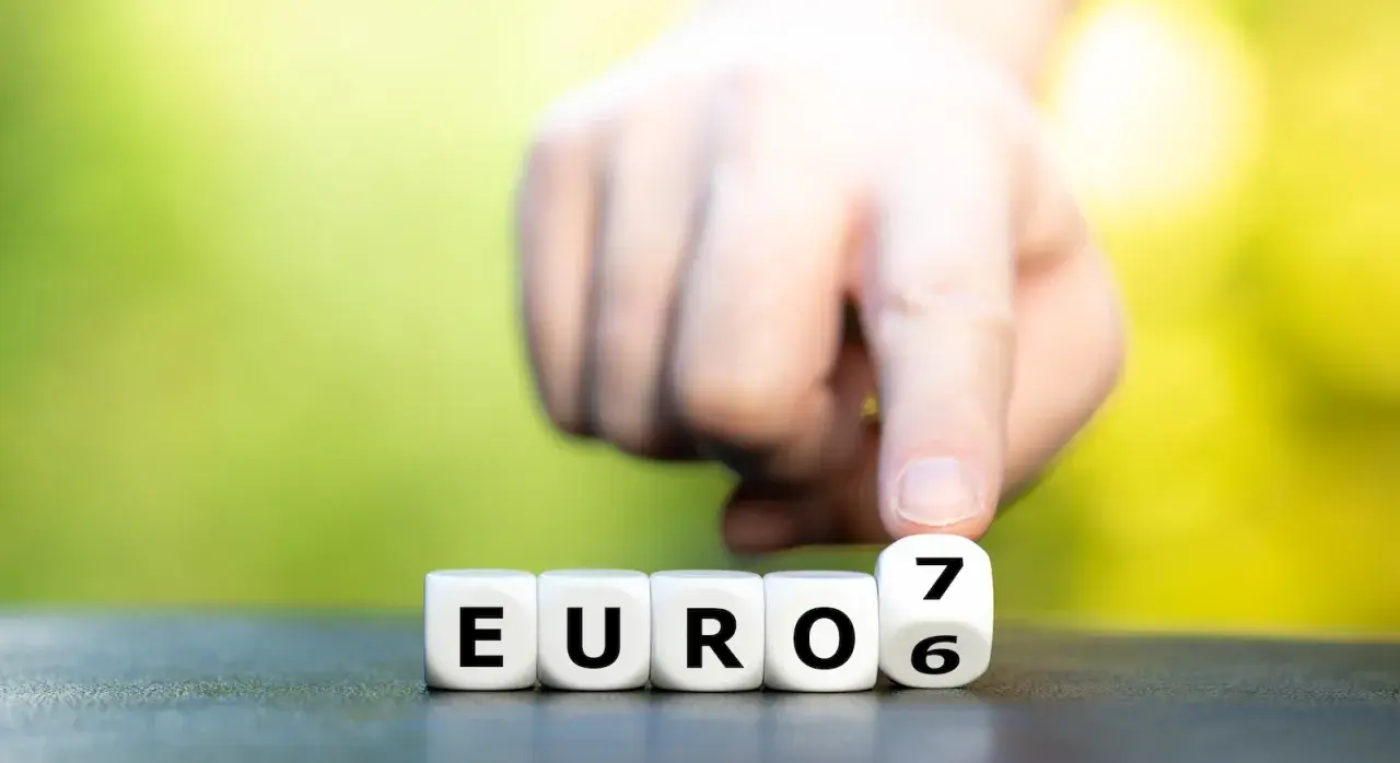 Dłoń przesuwa kostkę z cyfrą 7, tworząc napis "EURO 6".