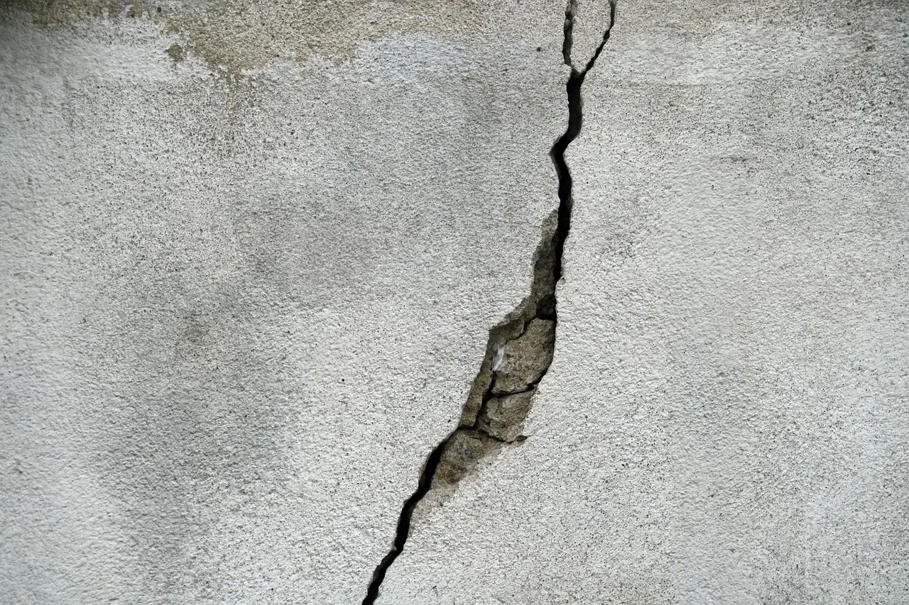 Pęknięcie na betonowej ścianie, które może wskazywać na ukryte przyczyny pękania ścian w blokach oddanych do użytku po 2024 roku.