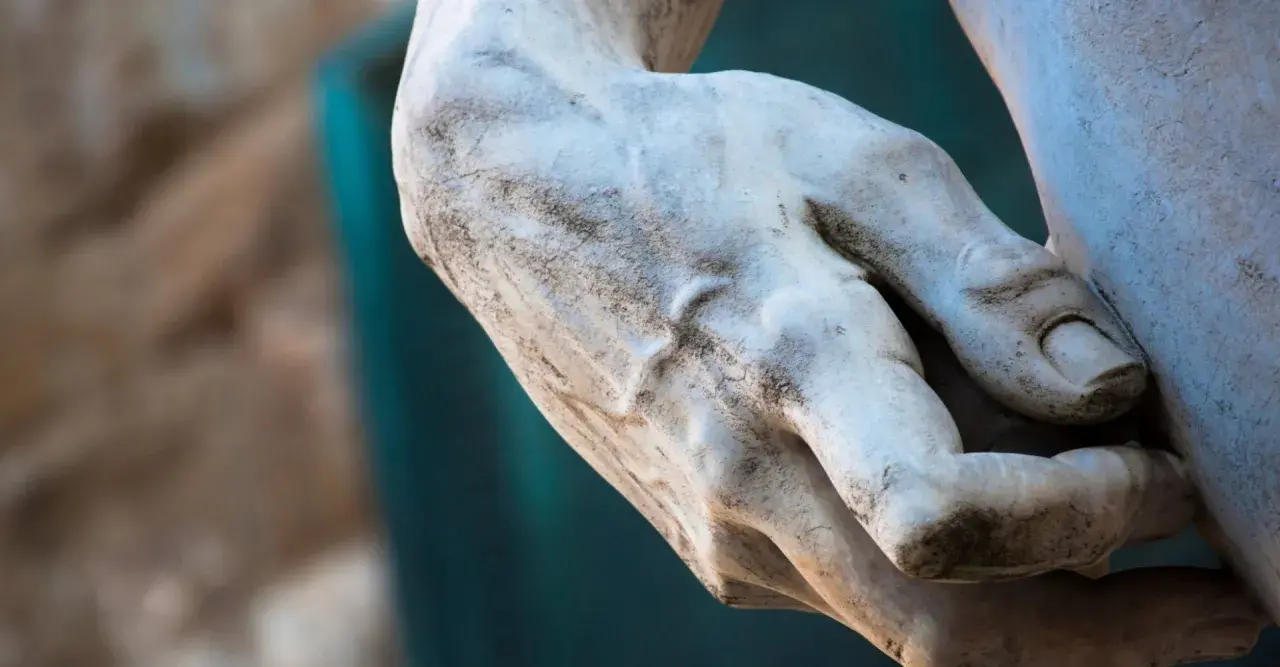 Détail d'une main sculptée, évoquant la puissance et la grâce d'une statue de Michel Ange.