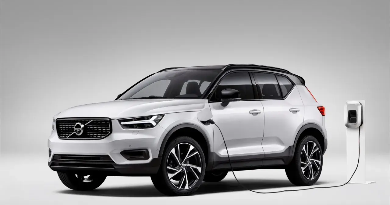 Biały Volvo XC40 Recharge plug-in hybrid podłączony do ładowarki.