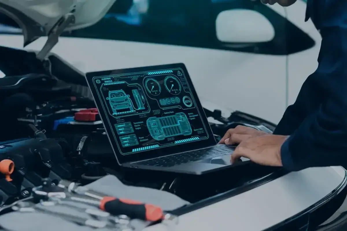 Diagnostyka komputerowa samochodu cena: mechanik analizuje dane z laptopa dotyczące elektrycznego pojazdu.