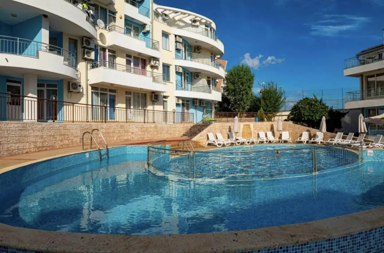 Słoneczna plaża w Bułgarii: basen z leżakami i hotel w tle, idealne miejsce na wakacje.