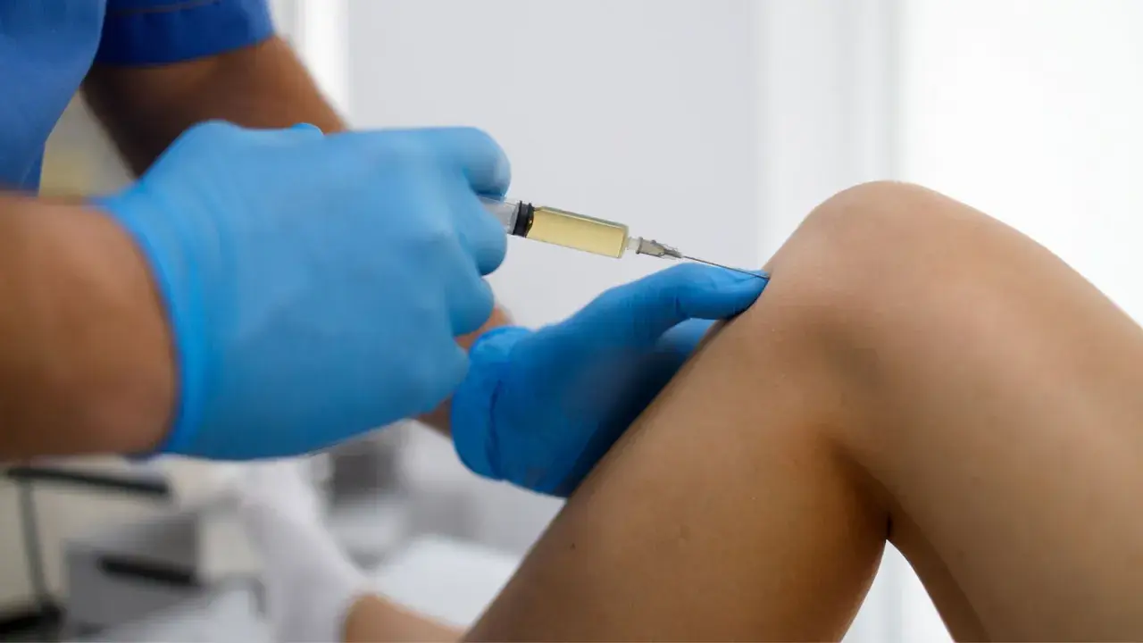 Arzt gibt Arthrose Spritze ins Knie.
