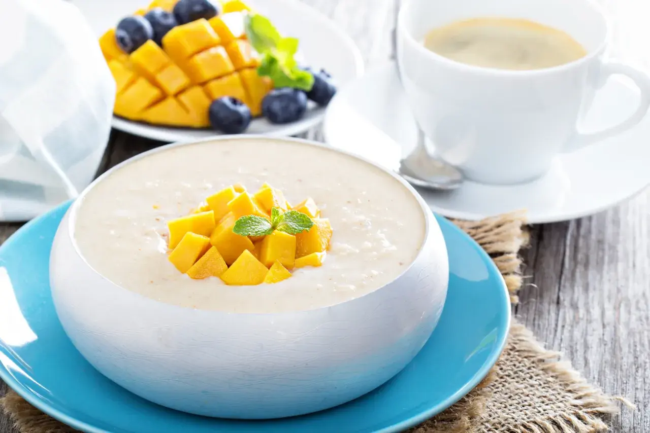 Pyszny deser z mango, jagodami i kawą. Ten mango smak to idealny początek dnia.
