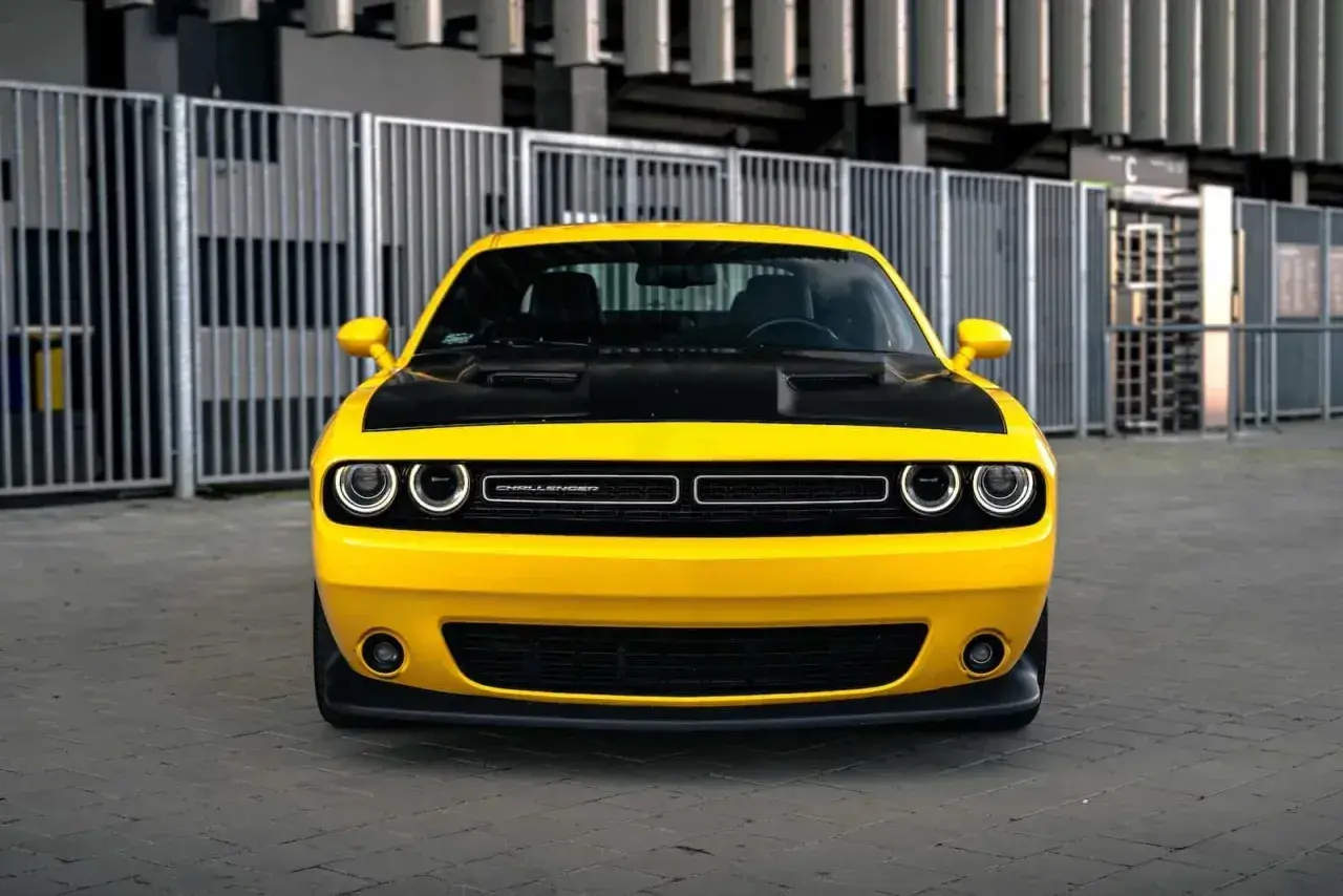Żółty Dodge Challenger z czarną maską, gotowy do jazdy. Sprawdź jego atrakcyjną dodge challenger cena!