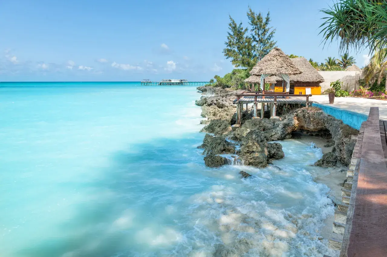 Turkusowe morze i tropikalna zabudowa na skale. Idealne miejsce na relaks, a zanzibar ceny mogą być zaskakująco przystępne.