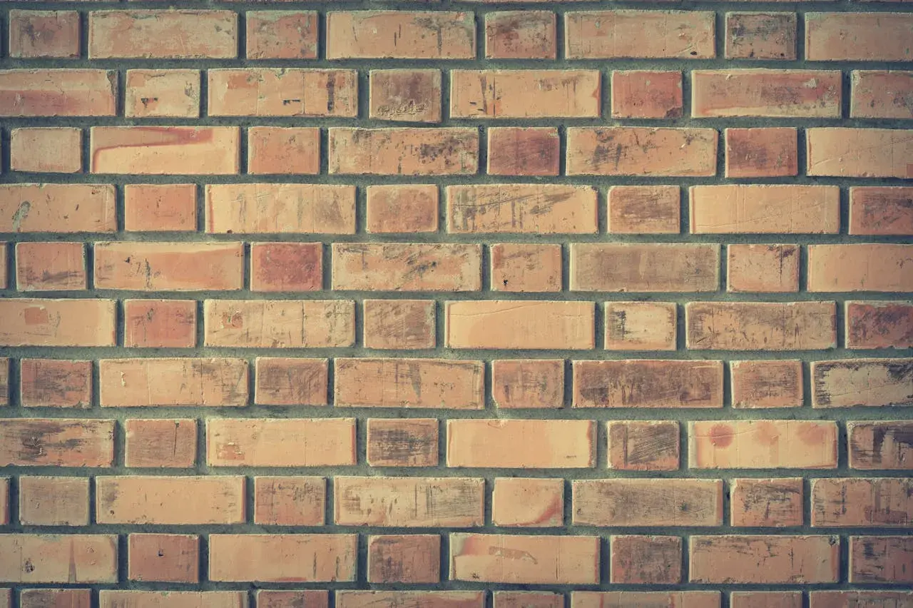 Ceglana ściana, idealna do budowy pieca. Zastanawiasz się, ile kosztuje cegła szamotowa?