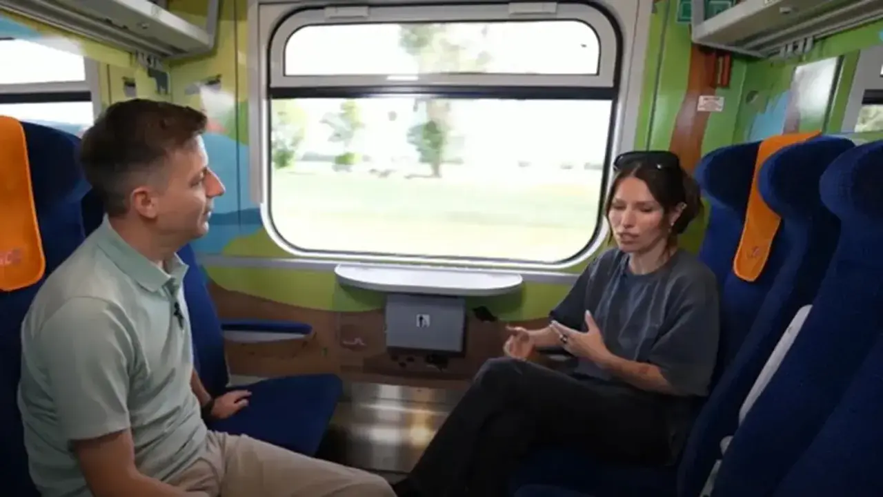 Rozmowa w wagonie z kolorowymi grafikami, być może w ramach specjalnego **metro programu** dla dzieci.