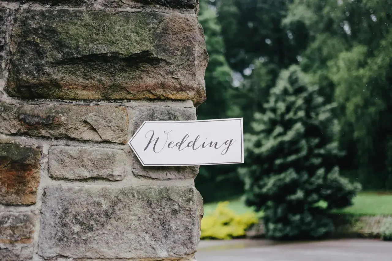 Strzałka z napisem "Wedding" wskazuje drogę do uroczystości, zapowiadając tradycyjny marsz weselny.