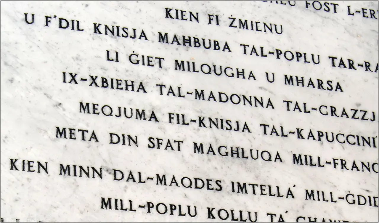 Napis na marmurze w języku maltańskim. Tekst opowiada historię o kościele i jego znaczeniu dla ludzi.