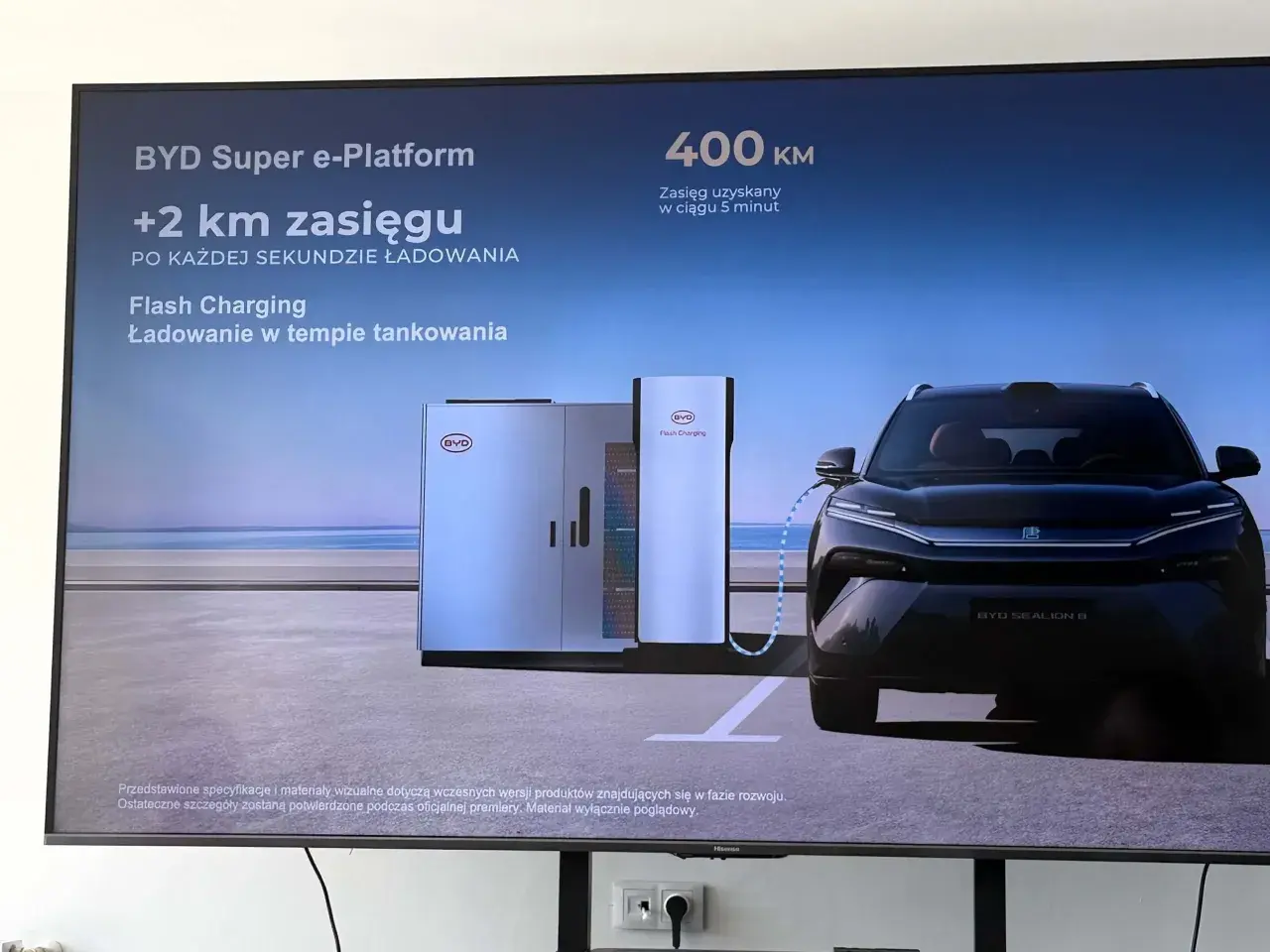 Czarny samochód elektryczny BYD Sealion 8 podłączony do stacji ładowania Flash Charging.