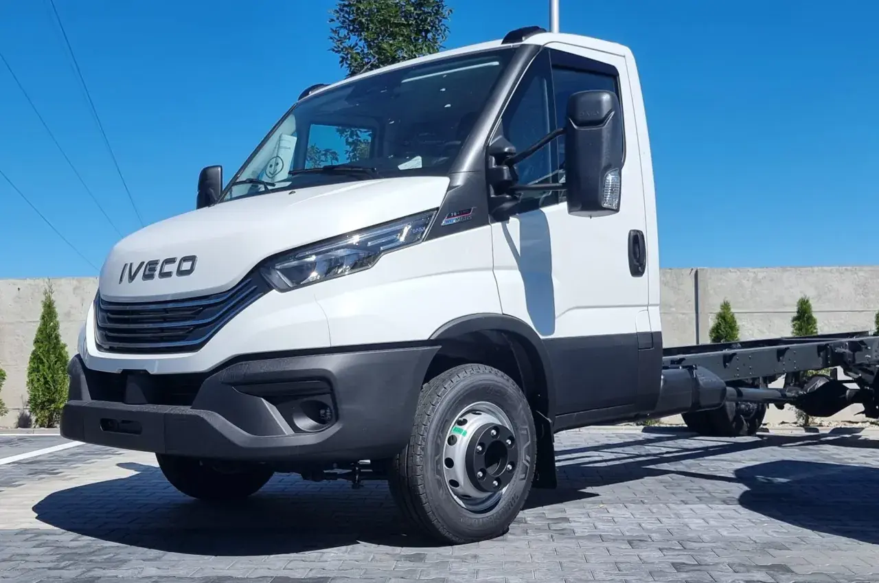 Biały Iveco 70C18, podwozie gotowe do zabudowy, stoi na placu z kostki brukowej.