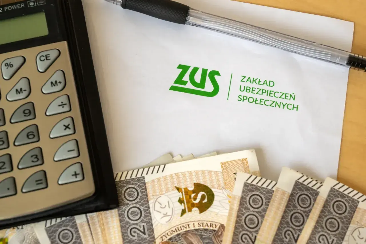 Kalkulator, długopis, banknoty i dokument ZUS. To ZUS wypłaca L4 ciążowe.
