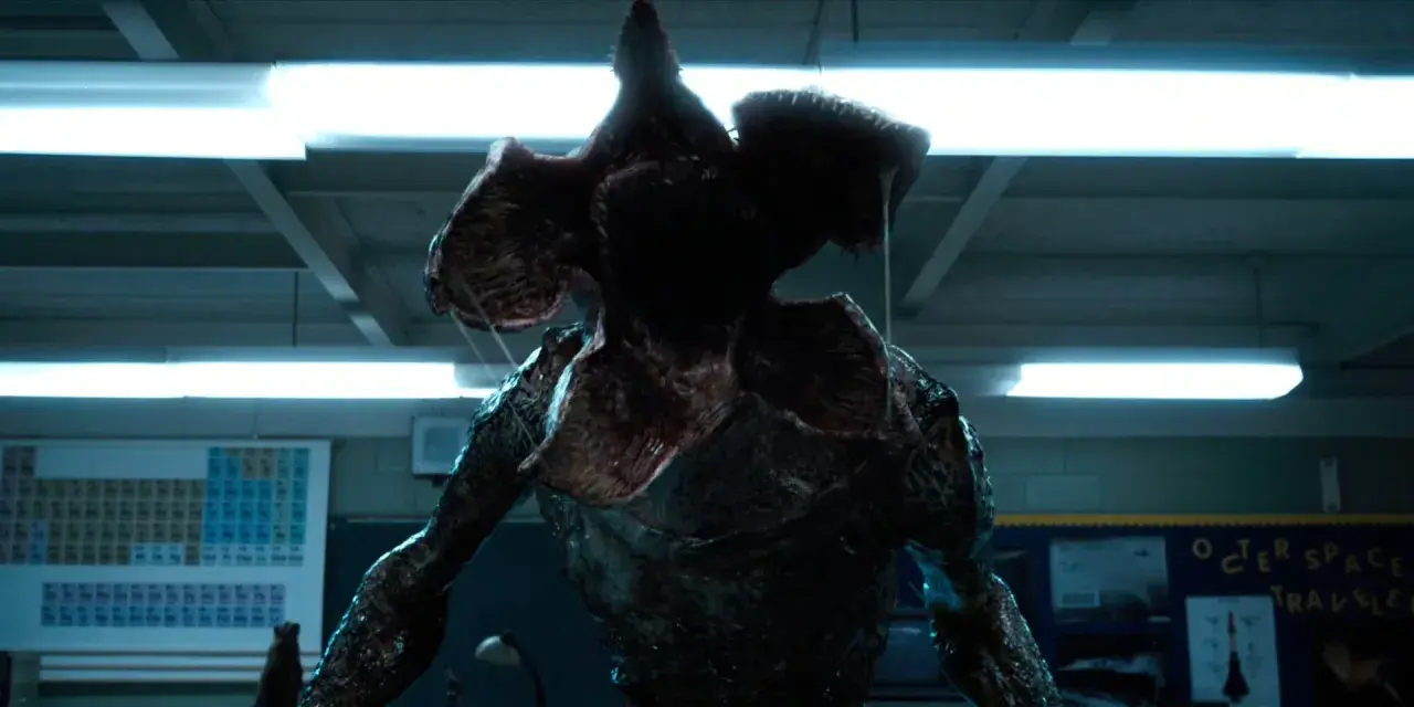 Potwór z serialu Stranger Things, Demogorgon, z otwartą paszczą w klasie.