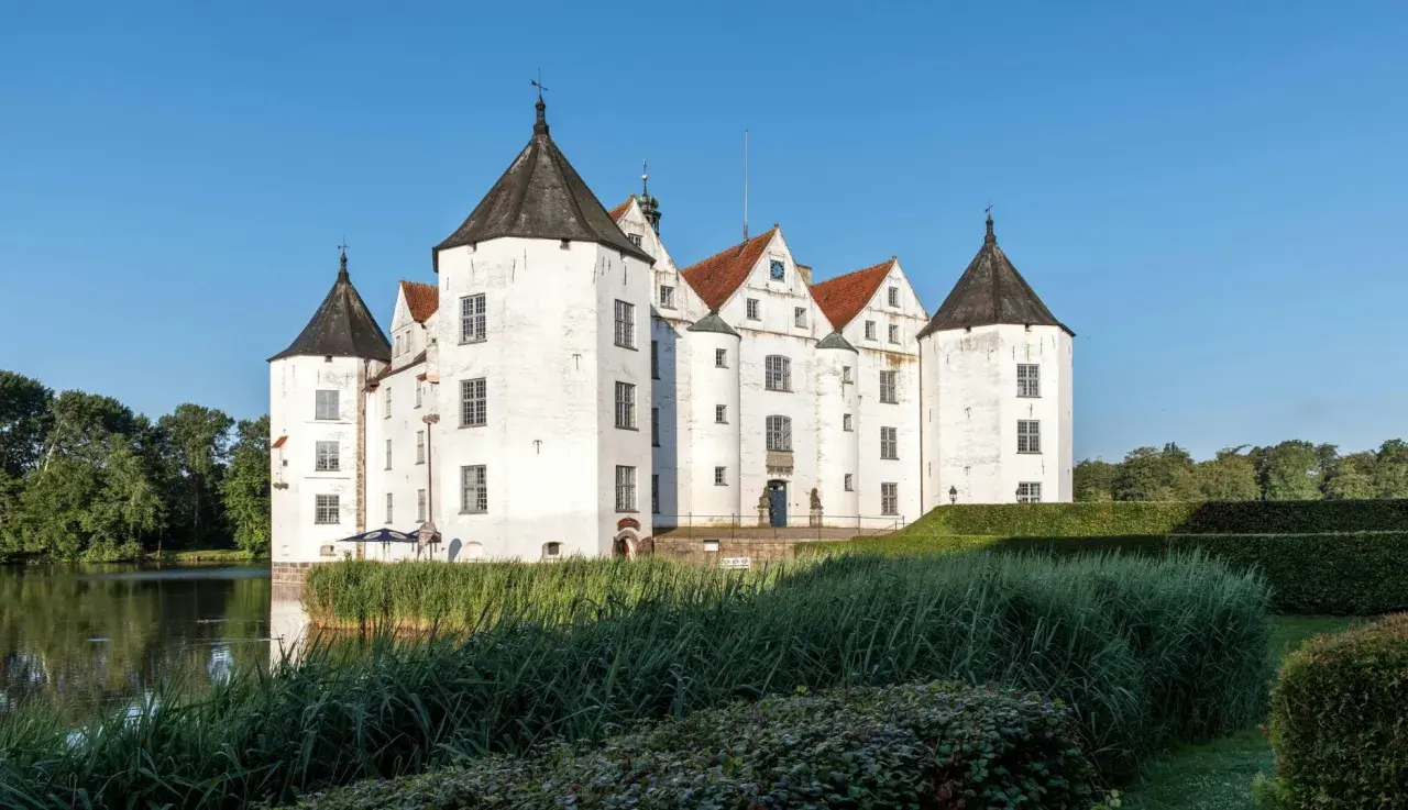 Wasserschloss in Schleswig-Holstein, ideal für die herbstferien 2025. Ein malerisches Schloss mit Türmen und Wassergraben.