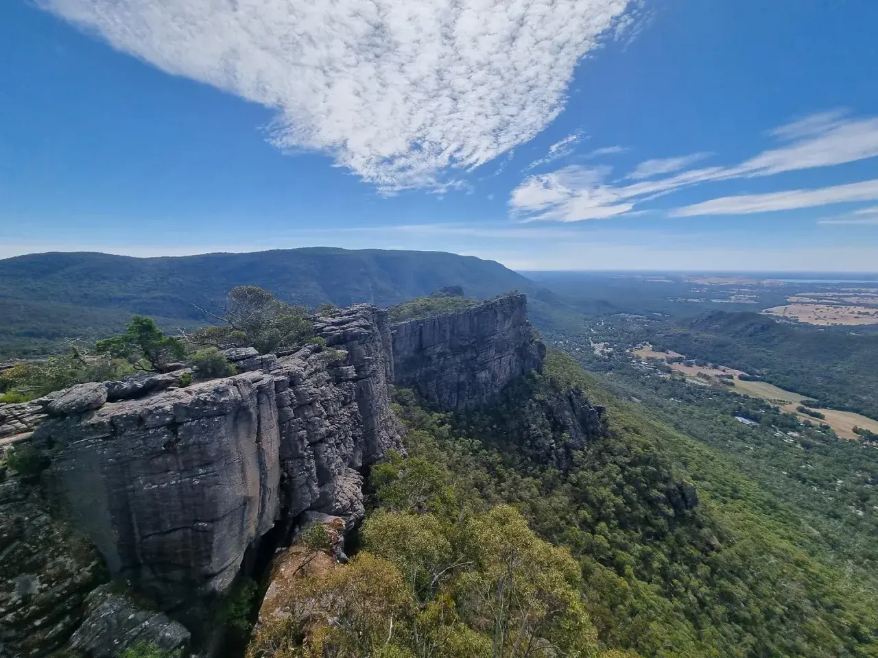 Majestatyczne australijskie góry Grampians z klifami i zielonymi dolinami pod błękitnym niebem.