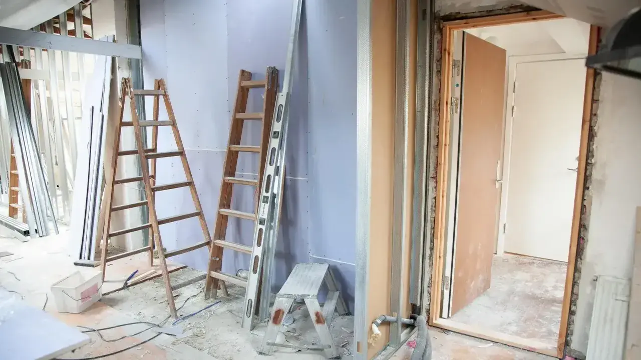 Remont mieszkania 60m2 w toku. Drabiny, poziomica i materiały budowlane wskazują na prace.