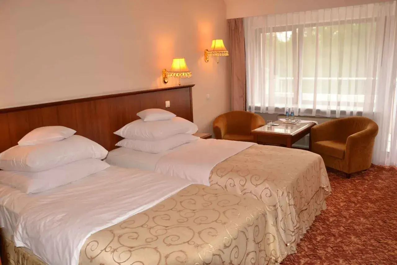 Przytulne hotel Gołębiewski pokoje z dwoma wygodnymi łóżkami, stolikiem i dwoma fotelami.