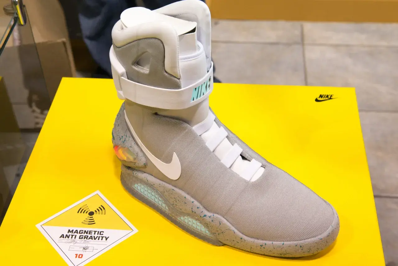 Nike Mag, najdroższe buty na świecie, z technologią "Magnetic Anti Gravity", prezentowane na żółtym tle.