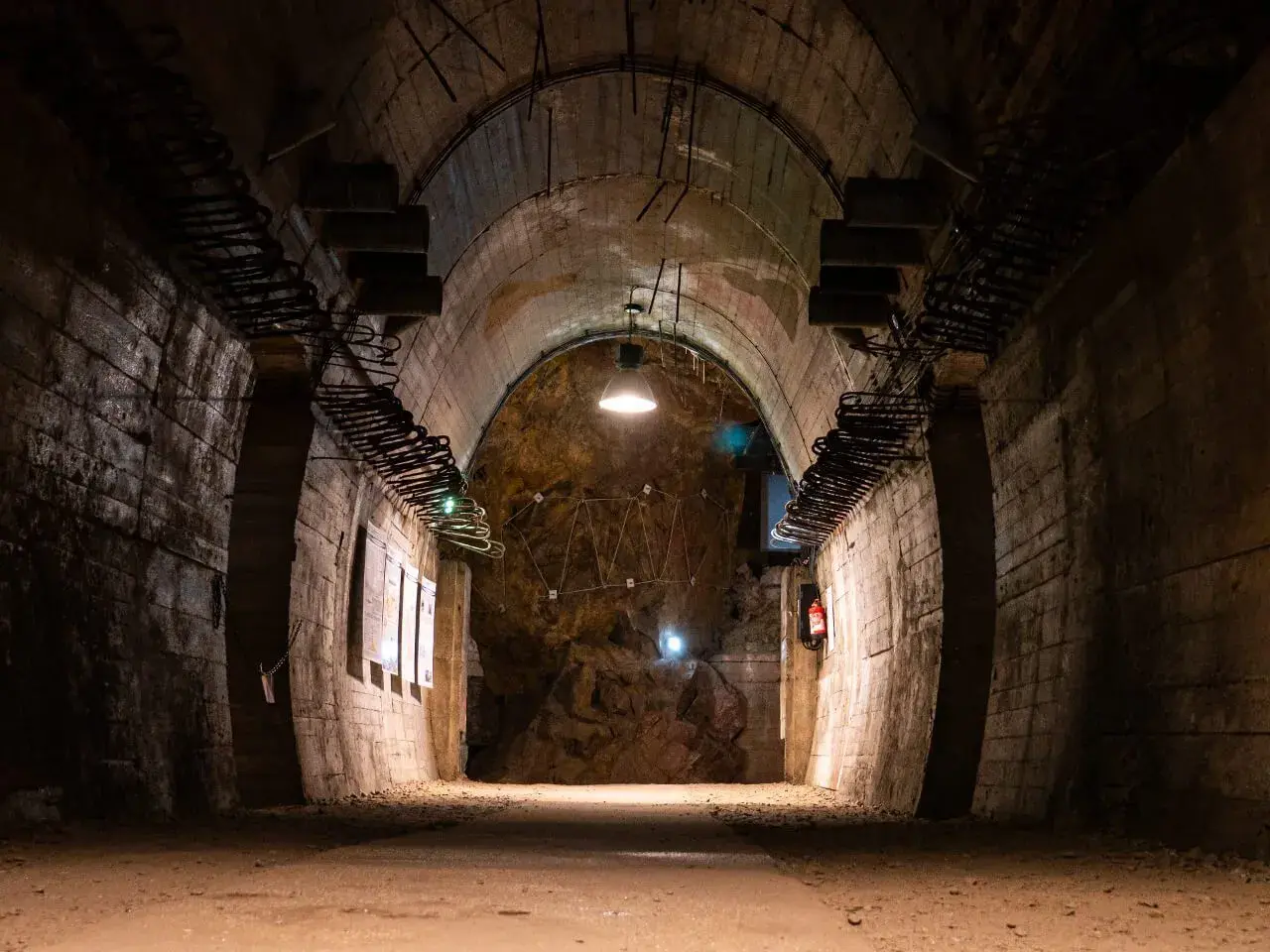 Wnętrze tunelu w Kompleksie Riese. Warto zobaczyć surowe ściany, odsłonięte zbrojenia i tajemniczą instalację na końcu.