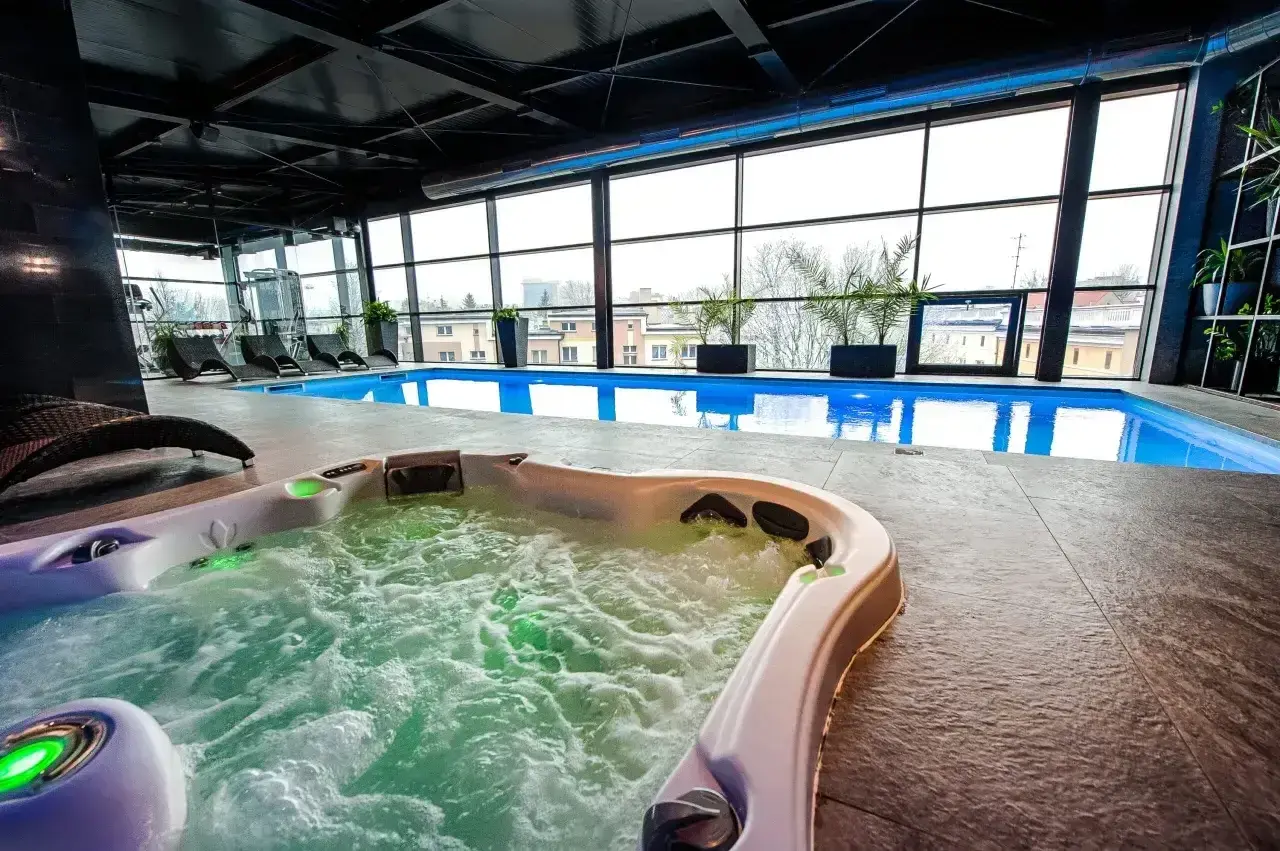 Relaks w hotelowym spa w Białymstoku: jacuzzi z bąbelkami i basen z widokiem na miasto.