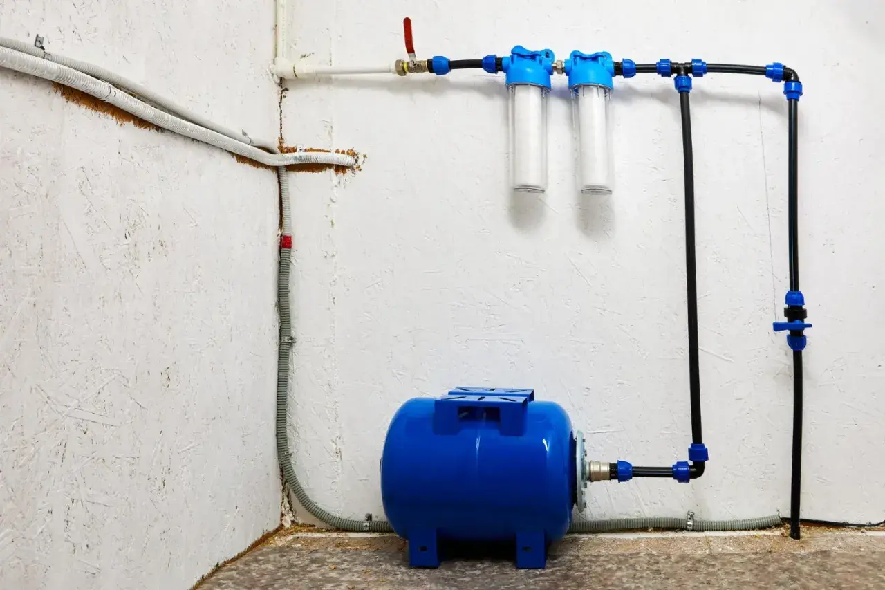 System hydrofornia z niebieskim zbiornikiem, dwoma filtrami wody i instalacją rurową.