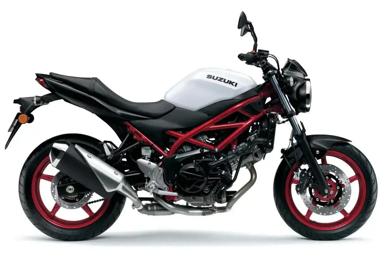 Biały motocykl Suzuki SV 650 z czerwonym stelażem, idealny do miasta. Poznaj suzuki sv 650 dane techniczne.