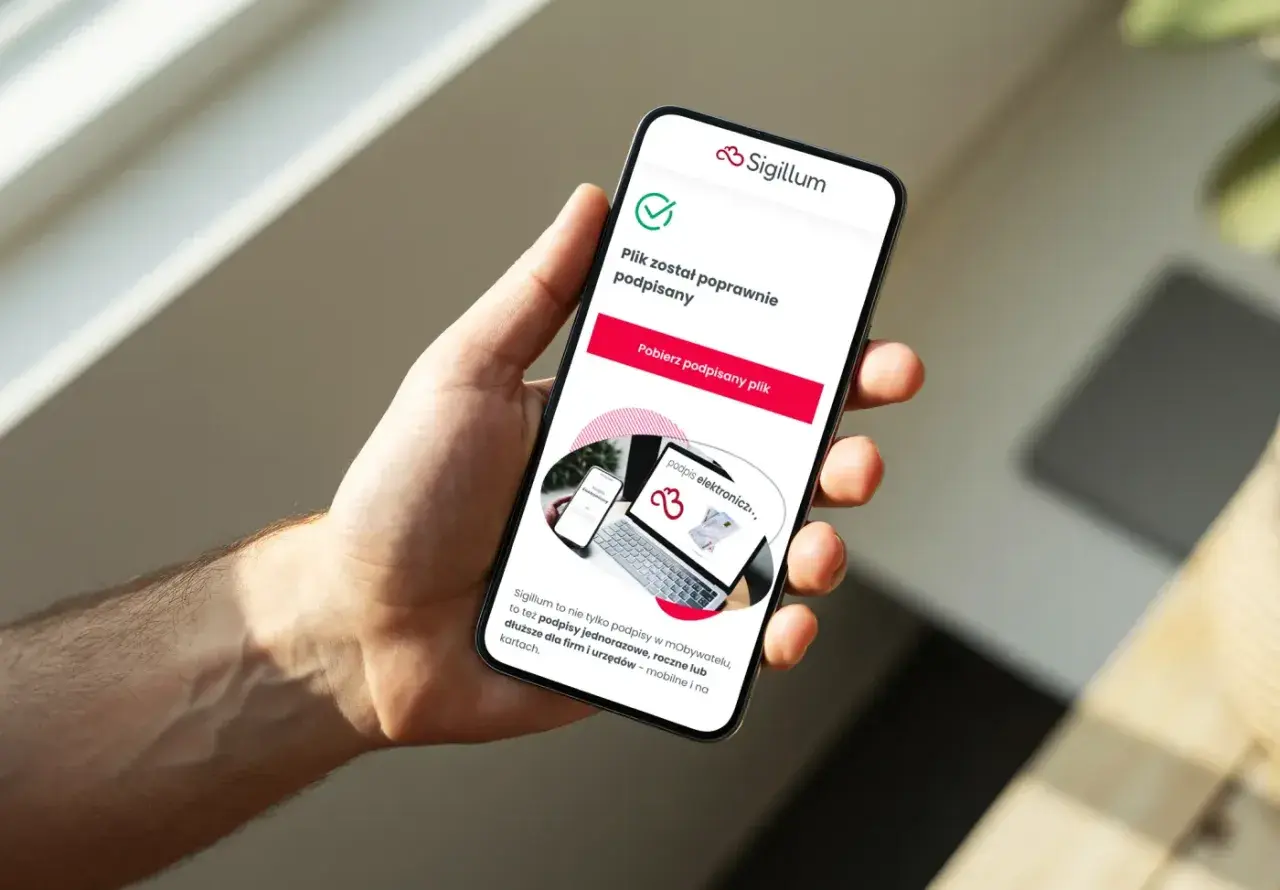 Dłoń trzyma smartfon z potwierdzeniem podpisu elektronicznego. Sigillum oferuje podpisy dla każdego obywatela.