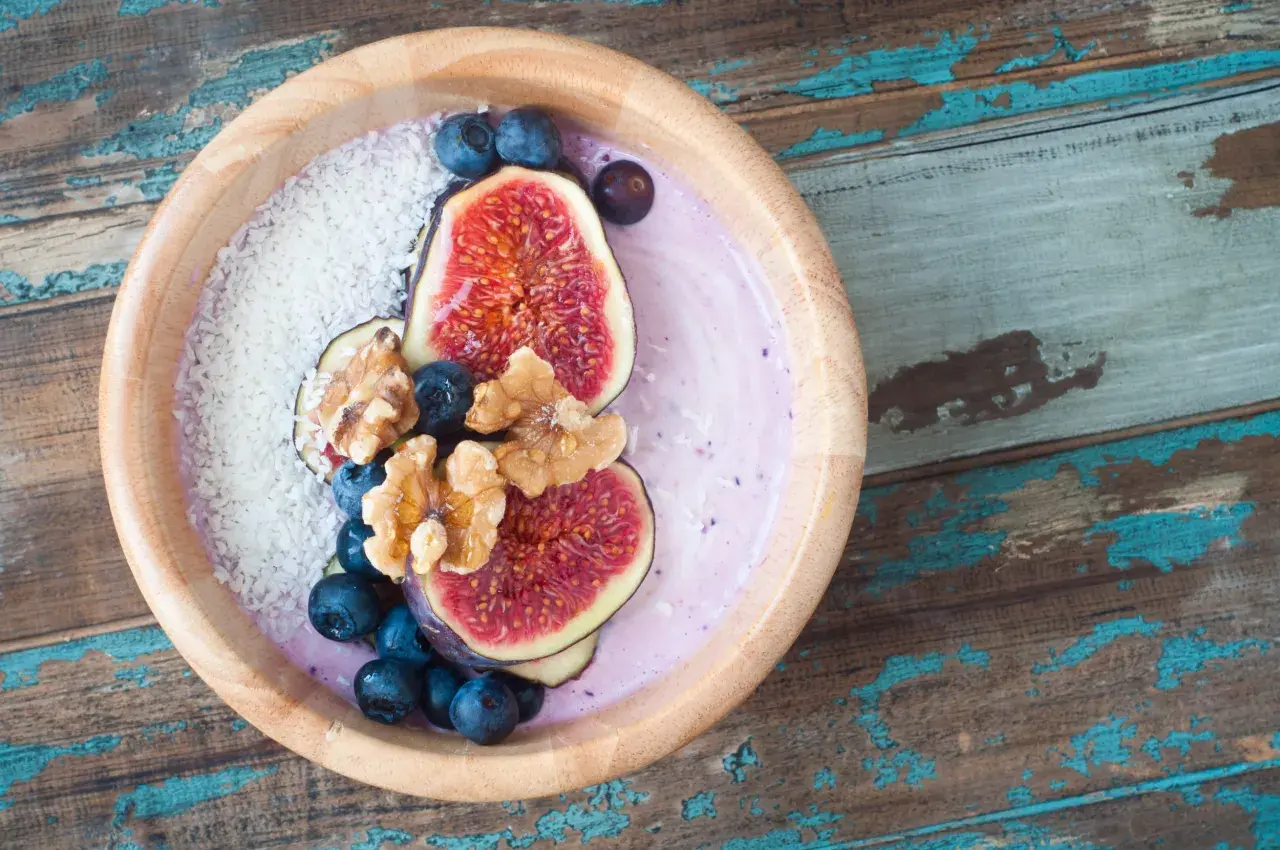 Smoothie bowl z figami, borówkami i wiórkami kokosowymi, przypominający wyglądem tradycyjny kisiel.