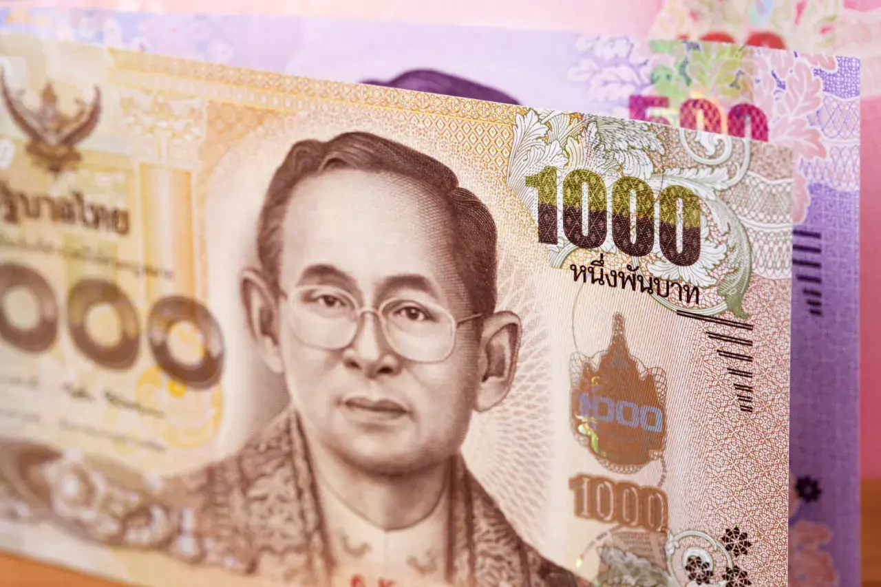 Tajskie baty: banknot 1000 bahtów z wizerunkiem króla i banknot 500 bahtów w tle.