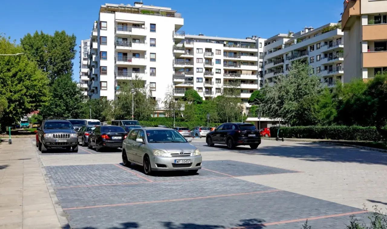 Nowoczesne osiedle w Warszawie, parking z samochodami. Zastanawiasz się, ile kosztuje kawalerka w Warszawie?