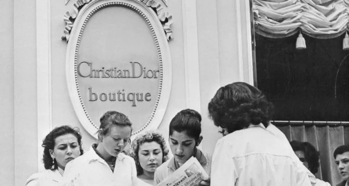 Donne leggono un giornale davanti alla boutique Christian Dior, dove nasce la moda.