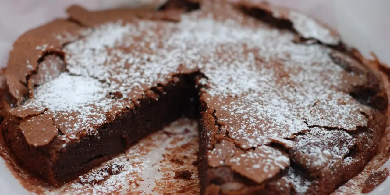 En saftig kladdkaka, pudrad med florsocker, redo att avnjutas. Perfekt för fikat eller som en del av ett dessertbord med andra kladdkaka kakor.
